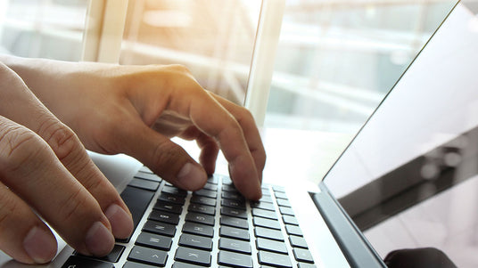 hands on laptop keyboard