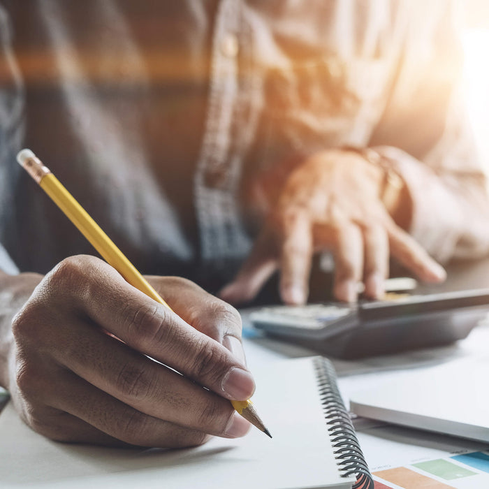 Writing on notepad with calculator